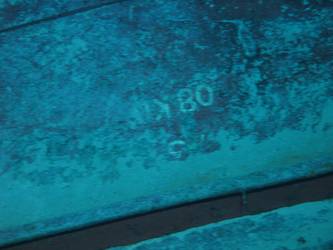 Large section of hull in debris field with "08KO" painted on plating